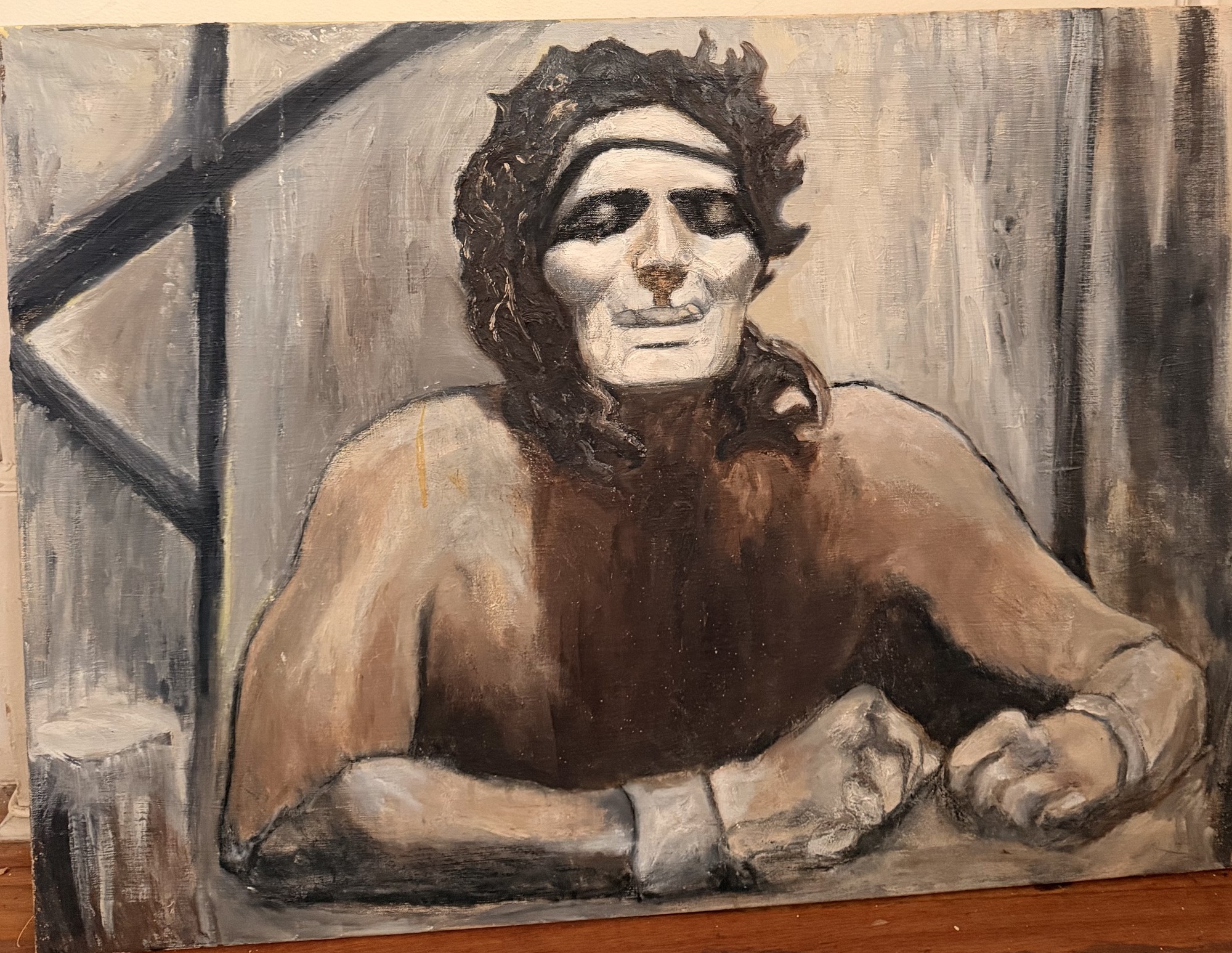 Monumental seated figure with a pale face and dark curling hair, arms folded on a ledge, painted in greys and umbers in oil on linen